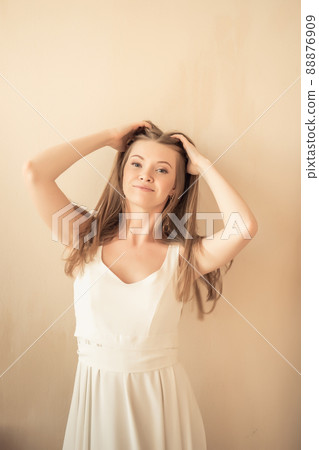 young girl with fingers in her hair, looking at camera and smiling young girl with fingers in her hair, looking at camera and smiling 88876909