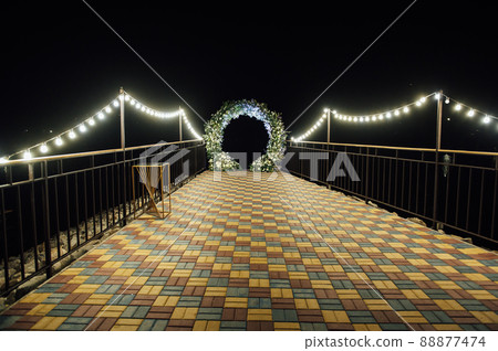 Round wedding arch decorated with fresh flowers. Evening ceremony Round wedding arch decorated with fresh flowers. Evening ceremony 88877474