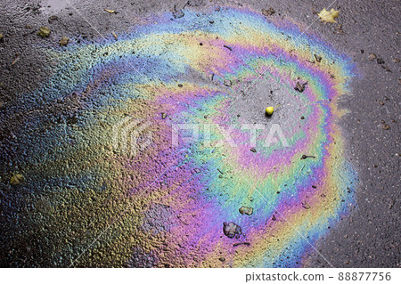 Iridescent spot of gasoline. Petrol on the asphalt a big polluted puddle water. A rainbow slick of gasoline 88877756
