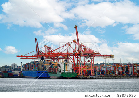International cargo ship with containers cargo cranes and helicopter flying on port at coastline 88878659