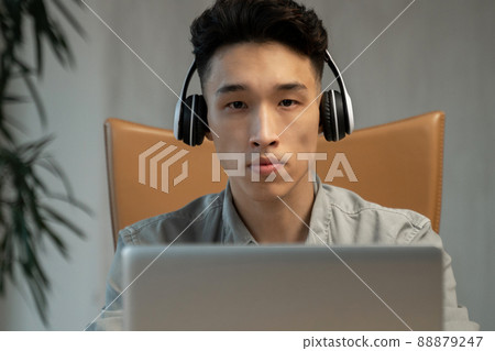 Young Asian employee puts on headphones to talk to customer 88879247