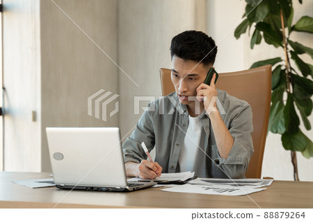 Asian secretary calls to manager explaining issue at work Asian secretary calls to manager explaining issue at work 88879264