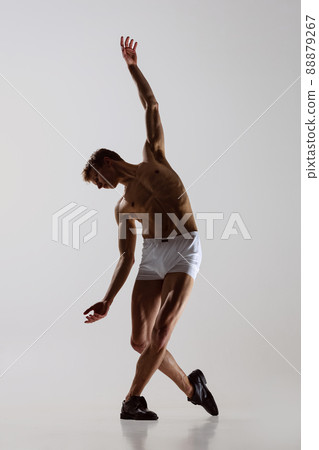 Contemp dance, performance. Young flexible shirtless man in underwear dancing isolated on gray background. Art, music, beauty. Healthy lifestyle concept 88879267