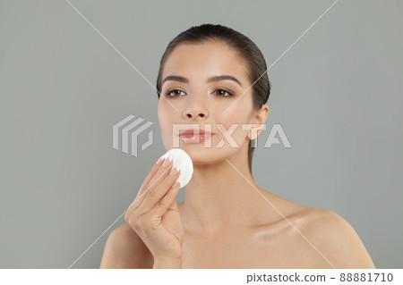 Cute woman removing makeup with cotton pad, portrait 88881710