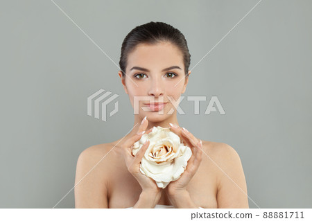 Portrait of beautiful healthy woman with clean skin and rose flower on grey background 88881711