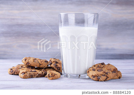 A stack of chocolate chip cookies lies near a glass of milk. Calcium-rich milk. A stack of chocolate chip cookies lies near a glass of milk. Calcium-rich milk. 88884120