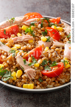 Boiled spelled with tuna, corn, tomatoes and herbs close-up in a plate. vertical Boiled spelled with tuna, corn, tomatoes and herbs close-up in a plate. vertical 88885107