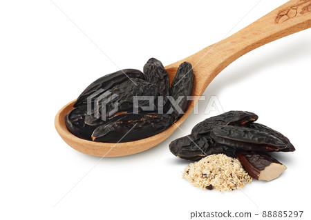 Tonka bean in wooden spoon isolated on white background with clipping path and full depth of field. Bean of Dipteryx odorata 88885297