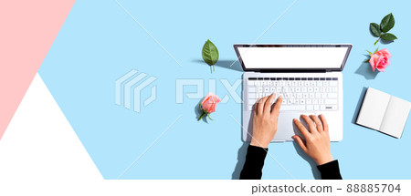 Woman using her laptop with pink roses 88885704