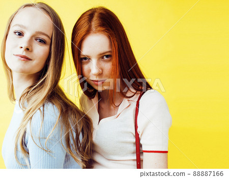 lifestyle people concept: two pretty young school teenage girls having fun happy smiling on yellow background closeup 88887166