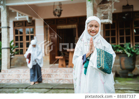 muslim girl with hijab smiling and greeting to camera muslim girl with hijab smiling and greeting to camera 88887337