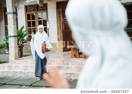 muslim woman with hijab waving at her friend muslim woman with hijab waving at her friend 88887347