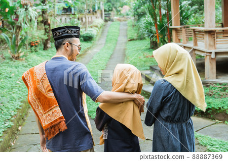 muslim family walking from their house to the mosque for eid mubarak prayer 88887369