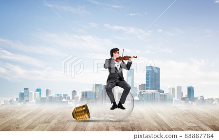 Young businessman plays the violin Young businessman plays the violin 88887784