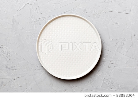 Top view of empty light plate on cement background. Empty space for your design 88888304