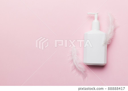 Set of skin care serums on pink pastel background with ostrich feathers. Spa cosmetic product, cream jar, branding mock up, top view with copy space 88888417