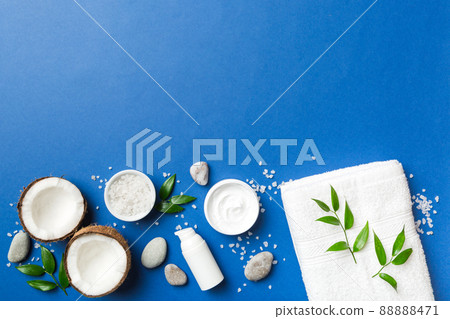 Coconut with jars of coconut oil and cosmetic cream on colored background. Top view. Free space for your text. Natural spa coconut cosmetics and organic treatment concept Coconut Spa composition Coconut with jars of coconut oil and cosmetic cream on colored background. Top view. Free space for your text. Natural spa coconut cosmetics and organic treatment concept Coconut Spa composition 88888471