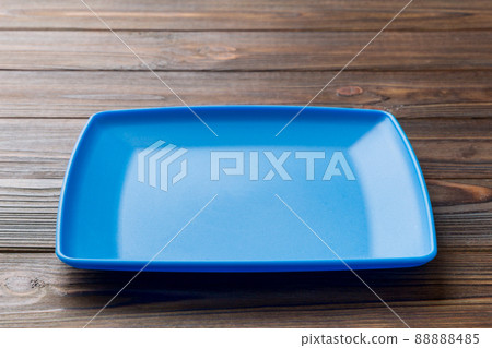 Perspective view of empty square plate on wooden background. Empty space for your design 88888485