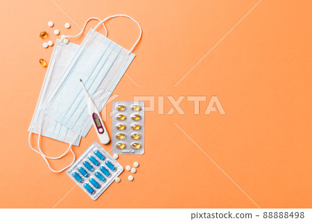 Protective face masks or surgical masks, medicine pills and thermometer on table background. Coronavirus disease. Corona virus concept. Space for text 88888498
