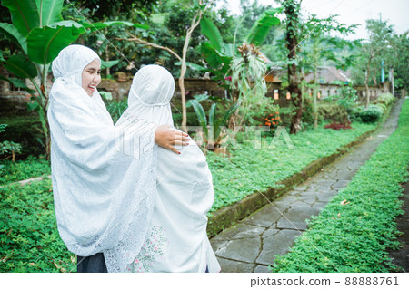 muslim mother and daughter walking to the mosque while wearing hijab muslim mother and daughter walking to the mosque while wearing hijab 88888761