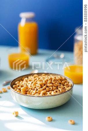 Breakfast concept with cold cereals and orange juice on blue background 88888996