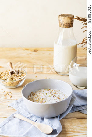 Healthy milky porridge from whole hulled grain oats in bowl with oat milk Healthy milky porridge from whole hulled grain oats in bowl with oat milk 88889029