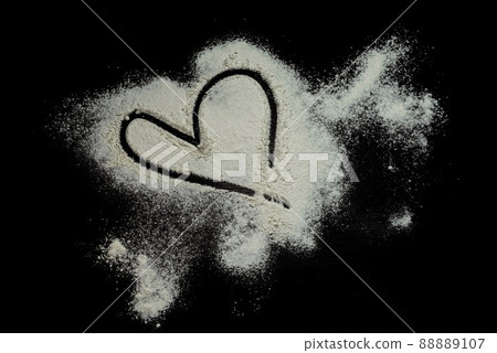 Black background sprinkled with flour heart shape, smeared flour, table for cooking, rolling dough. Preparing for baking, top view isolated on a black background or table. Love concept. Black background sprinkled with flour heart shape, smeared flour, table for cooking, rolling dough. Preparing for baking, top view isolated on a black background or table. Love concept. 88889107