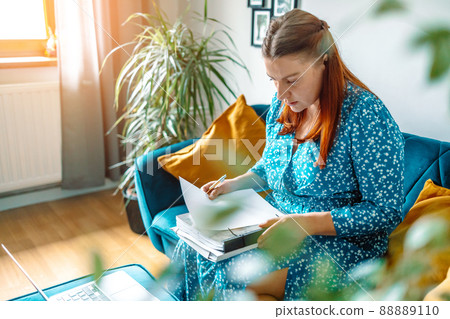 Woman calculating savings, taxes, insurance fees, counting budget, expenses, online financial app on laptop, doing paperwork. Woman calculating savings, taxes, insurance fees, counting budget, expenses, online financial app on laptop, doing paperwork. 88889110