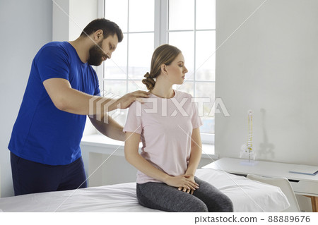 Professional chiropractor or physiotherapist helping patient who's undergoing rehabilitation 88889676