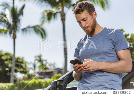 Car phone man driver using smartphone app for carsharing or travel vacation rental on new sports convertible. Summer holiday driving accident problem road trip assistance 88889802