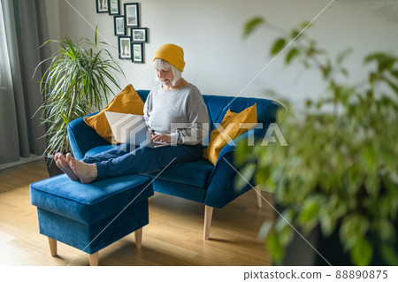 Mature beautiful blonde haired woman using laptop computer indoors. 88890875