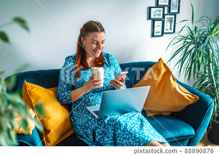 A beautiful young girl with laptop and mobile phone at home.  88890876