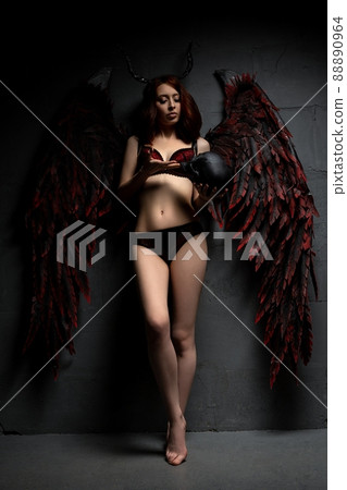 Sexy woman in provocative fallen angel concept with skull Sexy woman in provocative fallen angel concept with skull 88890964