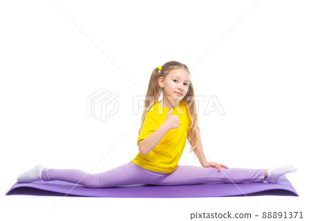 Little cute girl is practicing stretching on a gymnastic mat. Isolated on white background. 88891371