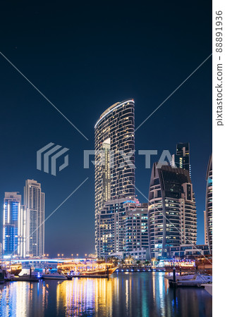 Night view Of Dubai Marina Towers. Yachts Moored Near City Pier, Jetty In Evening Night Illuminations 88891936