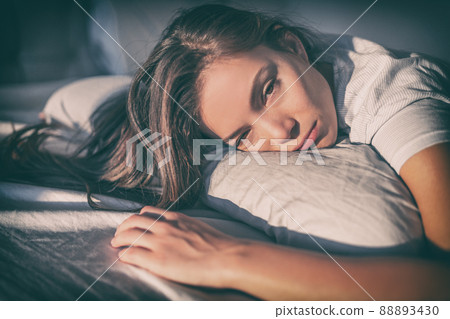 Depressed sad girl can't sleep late at night tired. Asian woman lying in bed up awake late at night with insomnia, sick with flu fever cold, or headache problem 88893430