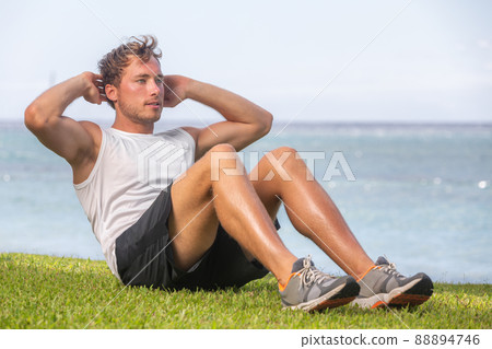 Fit man athlete training outside on grass doing situps for abs workout fat belly weight loss. Healthy active lifestyle Fit man athlete training outside on grass doing situps for abs workout fat belly weight loss. Healthy active lifestyle 88894746