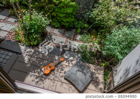 Enjoy the ukulele in the sun on the porch in a small garden with a gabion Enjoy the ukulele in the sun on the porch in a small garden with a gabion 88894980