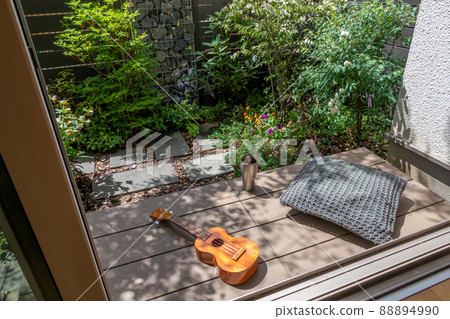 Enjoy the ukulele in the sun on the porch in a small garden with a gabion Enjoy the ukulele in the sun on the porch in a small garden with a gabion 88894990