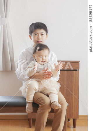 Brothers and sisters playing in the living room Brothers and sisters playing in the living room 88896175
