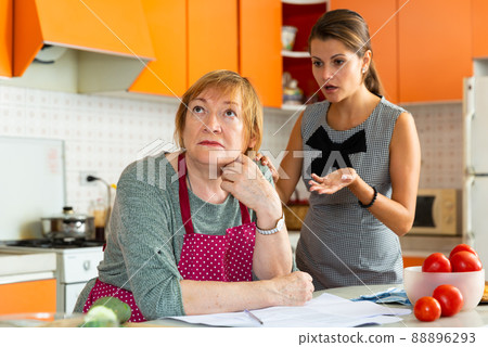 Quarrel of an elderly mother and adult daughter in the kitchen Quarrel of an elderly mother and adult daughter in the kitchen 88896293