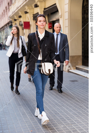 People in formal wear walking down street in city 88896440