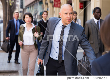 Hurrying businessman running on city street Hurrying businessman running on city street 88896445