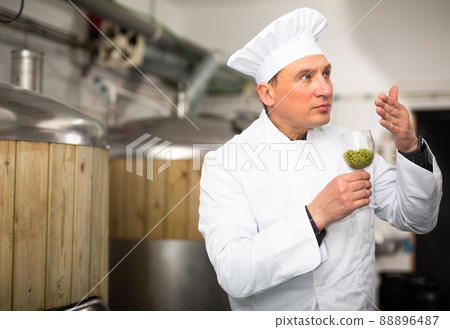 Brewmaster evaluating quality of hops pellets 88896487