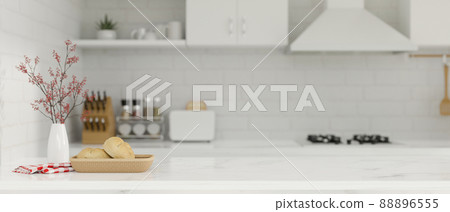 Copy space on white kitchen island over blurred kitchen interior background. Copy space on white kitchen island over blurred kitchen interior background. 88896555
