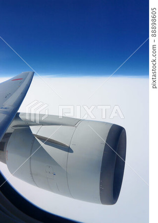 Scenery seen from an airplane, with engine blades, above the clouds 88898605