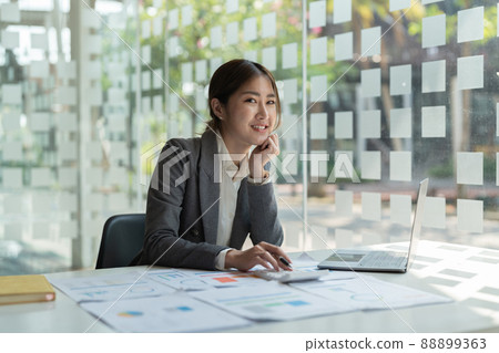 Smiling Business woman working in office with documents,Happy Asian businesswoman using laptop computer at modern office 88899363