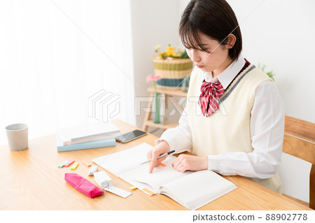 High school girl studying while watching a smartphone High school girl studying while watching a smartphone 88902778
