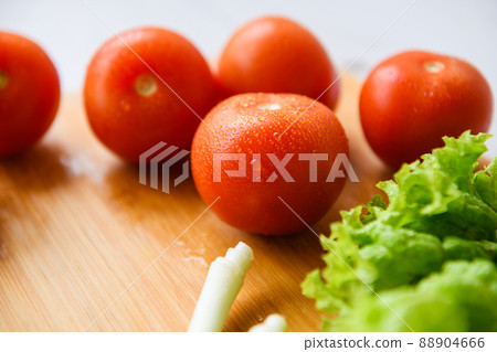 Fresh vegetables lie on a wooden cutting board Fresh vegetables lie on a wooden cutting board 88904666