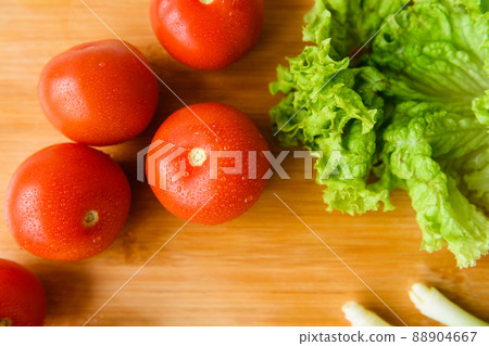 Fresh vegetables lie on a wooden cutting board 88904667